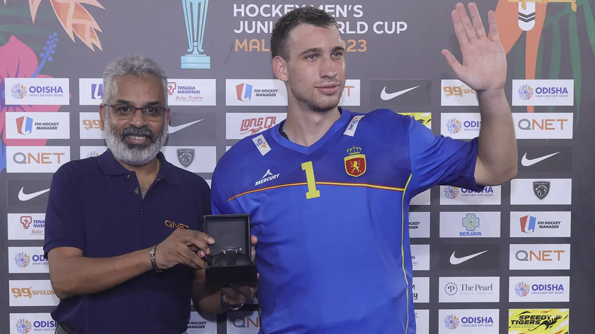 V Partner Sathi Senathirajah awards QNET's Man of the Match to Spain's Capellades Jan who waves to the crowd.