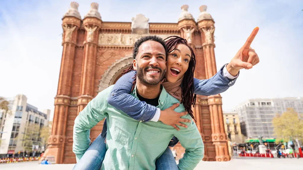 Youth entrepreneurs abroad, the guy is carrying the girl on his back while she points towards the horizon 