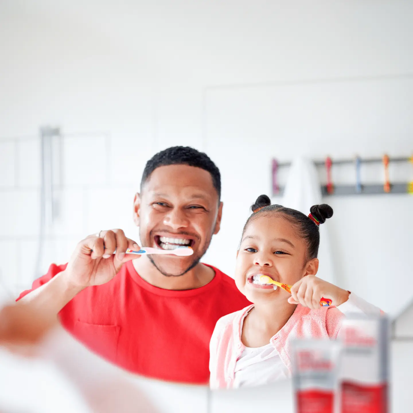 Dad and daughter brushing their teeth with Prospark toothpaste for great oral health