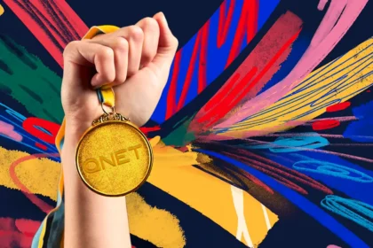 A hand holding a QNET gold medal to symbolize QNET Business Success and how QNET Champions Champions with its services and products