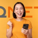 Excited woman holding her phone after a successful QNET Registration