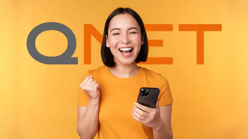 Excited woman holding her phone after a successful QNET Registration